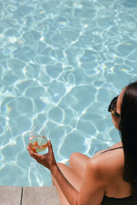 Lifestyle hospitality photography of a guest relaxing poolside at a boutique hotel in Southern California, photographed by commercial photographer Chelsea Loren.