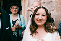colourful and candid wedding photography at weymouth church, brides mother looking at bride after confetti