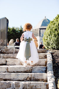 Husband and Wife photographer capture flower girl walking down the aisle in white dress
