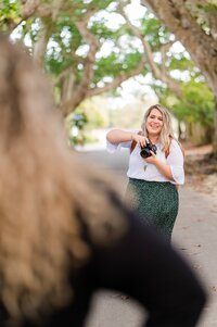 A photographer holds her camera in Downtown Main Street, Wauchula, Florida.