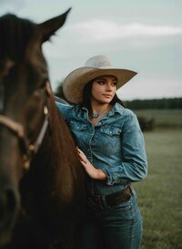 Senior girl wearing a cowboy hat posing with her horse at Triple T Farms in Fruitdale, Alabama.