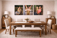 Three canvas family portraits arranged in a dining room with warm greige walls and natural wood tones