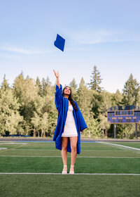 Sam Barlow High School senior throwing her graduation cap on the football field.