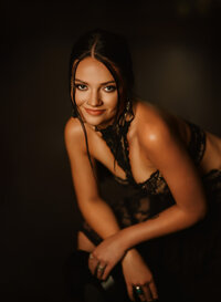 Senior portrait at Triple T Farms in Fruitdale, Alabama — smiling in a black lace dress while
holding a vinyl record.