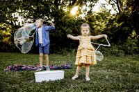 Two children play with large bubbles in a park in Southlake Texas.