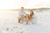 Family of four at beach during professional Niceville family photographer session