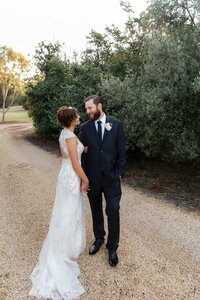 Bride and groom embracing outdoors during wedding portraits