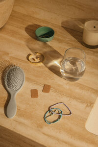 Overhead vanity flat lay with a hairbrush, water glass, and everyday personal items