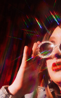 Colorful editorial portrait photographed with dramatic red lighting during a creative brand session.