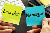 Two Post-it notes, one with word "leader" written on it and the other with "Manager"