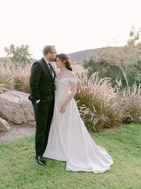 Newlyweds photographed together on a manicured golf course during their wedding day