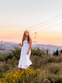 Luxury senior portraits for Sandy, Oregon high school senior at timberline lodge wearing a white dress in a field of wildflowers.