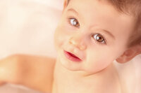 close up of one year old boy with bright brown eyes during birthday session by New Bern family photographer