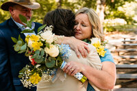 a mother of the bride embraces her son at the end of the aisle during their ceremony