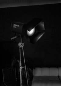 Black-and-white behind-the-scenes photograph of professional lighting equipment in a photography studio.