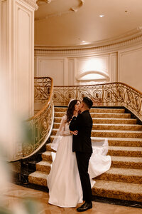 bride and groom kissing near a stairwell