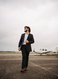 Senior portrait at a small hangar near Mobile International Airport in Mobile, Alabama — posing near airplane