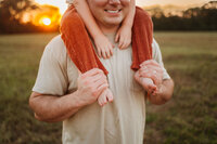 little kid sitting on dad's shoulders
