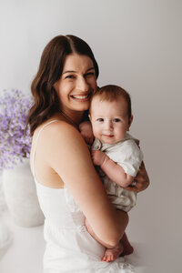 Charleston Mini Sessions - Mother embraces her baby during Mother's Day Mini Session at Holy City Babies in Charleston, SC.
