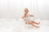 Baby looks at the camera during his first birthday Cake Smash Photoshoot at Holy City Babies Portrait Studio in Charleston, SC.