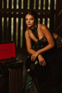 Senior portrait at Triple T Farms in Fruitdale, Alabama — close-up holding a vinyl record beside
an open vintage record player.