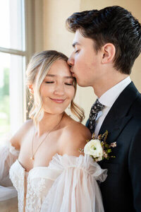groom kissing bride's forehead taken by wedding photographer north georgia