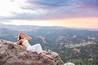 Colorado senior portrait at sunset—young woman in a white dress on the Lost Gulch Overlook with mountain views.