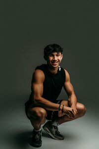 A student form Waukesha South High School poses for his senior photos wearing a black muscle shirt in our studio.
