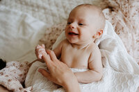 newborn baby snuggling in bed