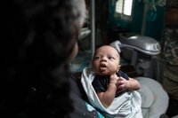 Orange Park newborn capturing a quiet in-home moment as a baby studies his mother’s face, eyes bright with early recognition and connection. (Photographed by Nature's Child Photography)