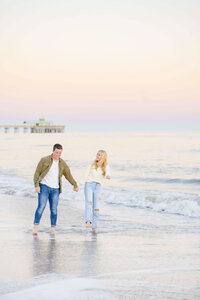 engaged couple playing in the waves in Charleston South Carolina