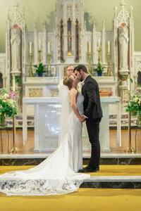 First kiss at the church in Los Angeles with warm ceremony lighting and an emotional documentary style moment.