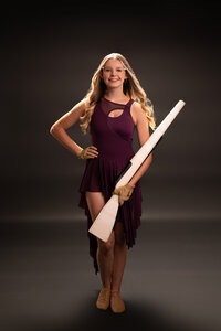 A member of the Arrowhead drill team poses for her senior portraits in our Waukesha studio wearing her uniform.