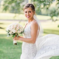 bride standing outside posing with bouquet