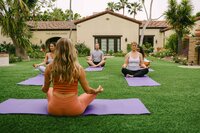 Yoga instructor leading a class on the lawn at The Woodlands, Estancia La Jolla hospitality campaign