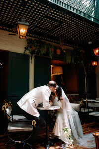 Bride and groom share a kiss at an intimate cafe during their Huntsville wedding.