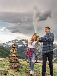 Couple celebrating a proposal near Big Bear Lake with a bottle of champagne during an outdoor engagement photo session.