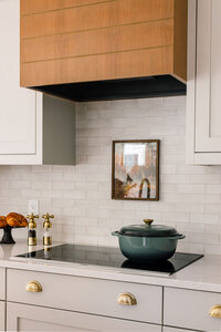warm and inviting photo of a renovated kitchen countertop with a dutch oven and vintage features