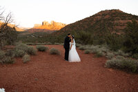 Bride and groom embracing amid Sedona's red rock formations during their elopement