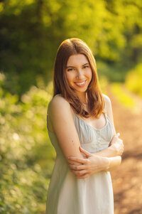 An Arrowhead High School senior stands in Eagle's Paradise Springs wearing a cotton sundress and posing with her arms crossed.