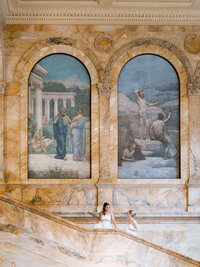 A documentary style wedding photography shot of a couple amidst the historic murals of the Boston Public Library, highlighting refined composition.