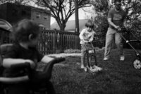 A dad and his son mow the grass