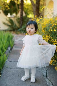 Toddler girl swaying her white tulle dress during a family photo session in Menlo Park