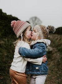 Sibling toddlers hugging and kissing