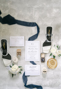 Bridal shoes, invitation, and jewelry flatlay