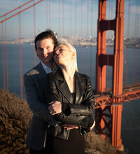 handsome couple lovingly embracing at sunset overlooking san francisco by the golden gate bridge