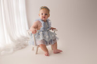 Baby gazes at the camera during her 1st birthday photoshoot at Holy City Babies Portrait Studio in Charleston, SC.