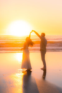 sunset beach couple twirling on sand barefoot in santa cruz