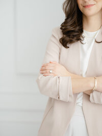 Close up branding/headshot photo of a Dallas TX business owner that is wearing a blush blazer and posing for the photographer.