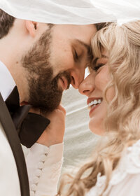 Couple kissing under brides veil at Camp Colton in Colton, Oregon